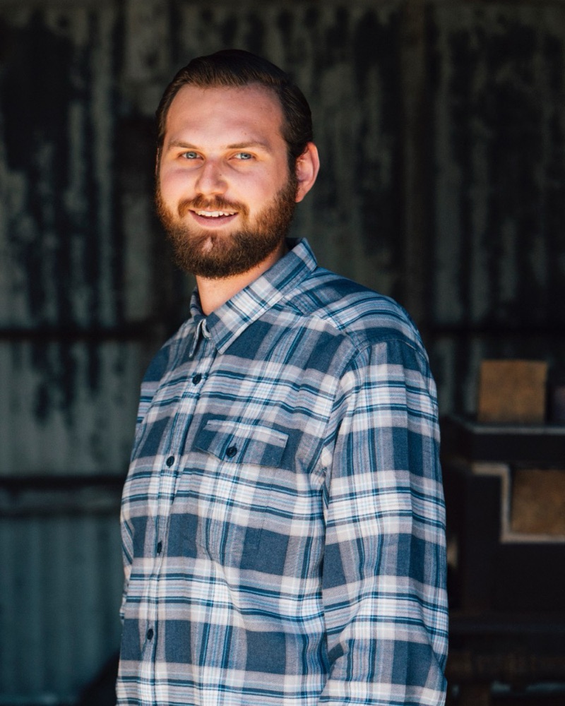 Colton Fouch, smiling, in a plaid flannel shirt